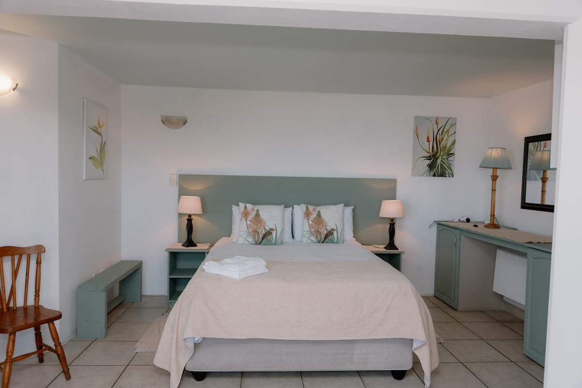 Cama tamaño queen con mesitas de noche y lámparas de lectura