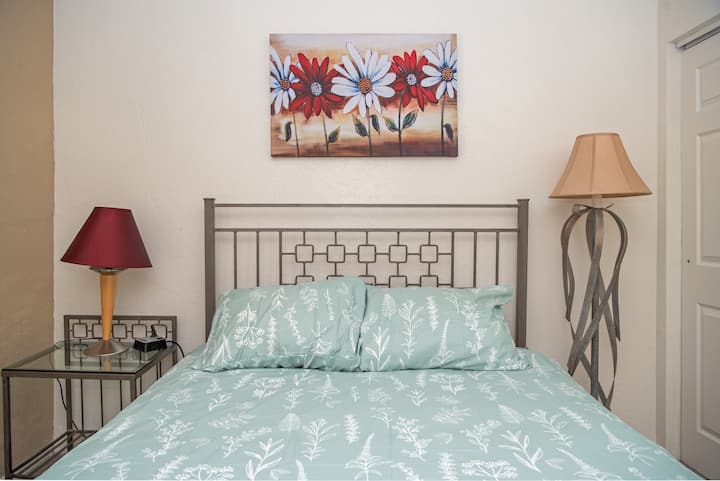 The bedroom features a comfortable queen-sized bed, dresser, closet, and blackout curtains for a great night's rest.