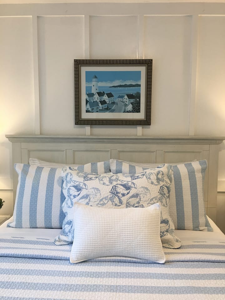 غرفة كوخ مليئة بالشمس تطل على الفناء الخلفي. 
سرير أوين.