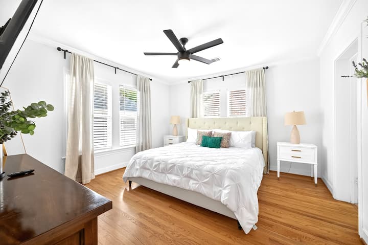 Dormitorio luminoso con cama tamaño king, ventanas grandes y cortinas suaves. La luz natural crea un refugio espacioso. Una televisión inteligente Roku de 65" añade entretenimiento. KingBedsOnly garantiza comodidad y modernidad.
