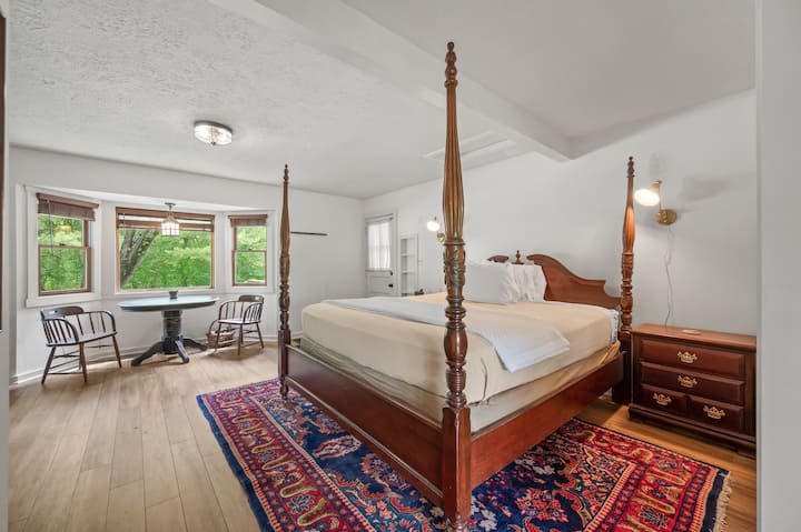 Four-poster king bedroom with table and chairs 