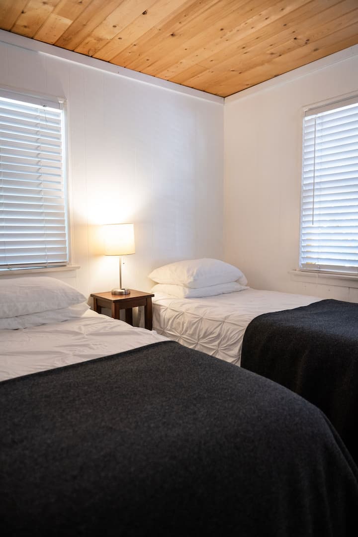 ห้องนอน 2 มีเตียงแฝดที่อบอุ่น 2 เตียงสร้างสถานที่พักผ่อนที่สะดวกสบายเหมาะสำหรับการพักผ่อน เหมาะสำหรับการนอนหลับพักผ่อนในที่พักที่มีเสน่ห์และเป็นกันเอง ห้องนอนนี้ยังมีห้องน้ำสไตล์แจ็คและจิล 