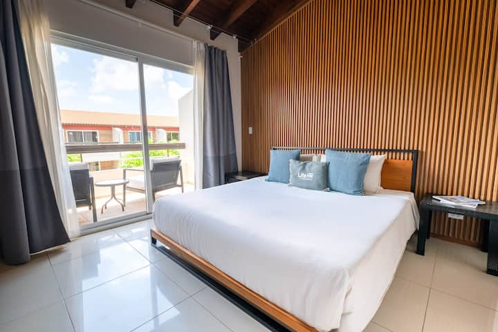 Despiértate con las tranquilas vistas al jardín desde el gran ventanal. El balcón privado es el lugar perfecto para disfrutar de tu café de la mañana y del aire fresco.