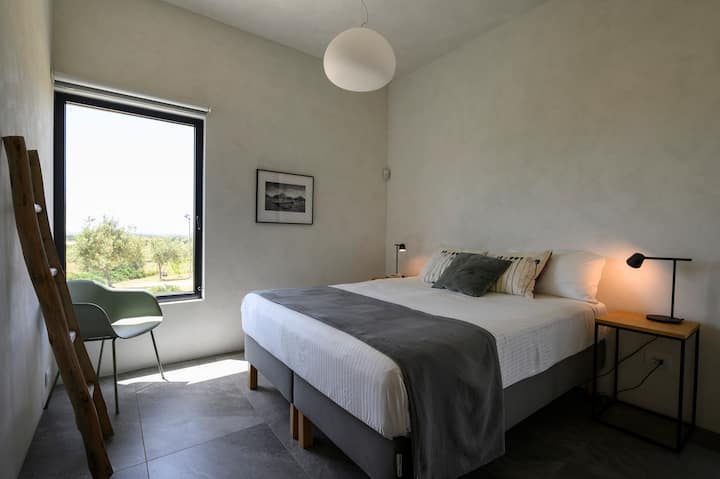 Chumba kikubwa kati ya vyumba viwili vya kulala kwenye ghorofa ya juu ya vila. Chumba hiki cha kulala kina picha kutoka kwa maestro Giuseppe Leone na mandhari ya bahari ya Mediterania. 