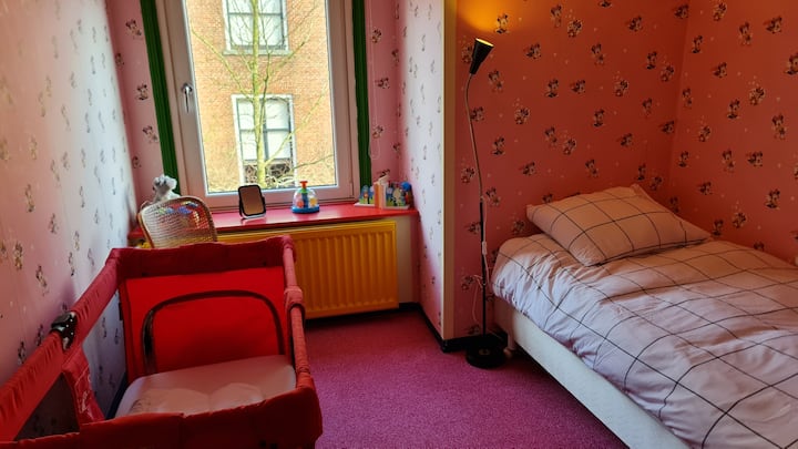 De 4e slaapkamer is een vrolijke kinderkamer met een babybedje en een 1 persoons bed. Ook hier mooi uitzicht door het grote raam.