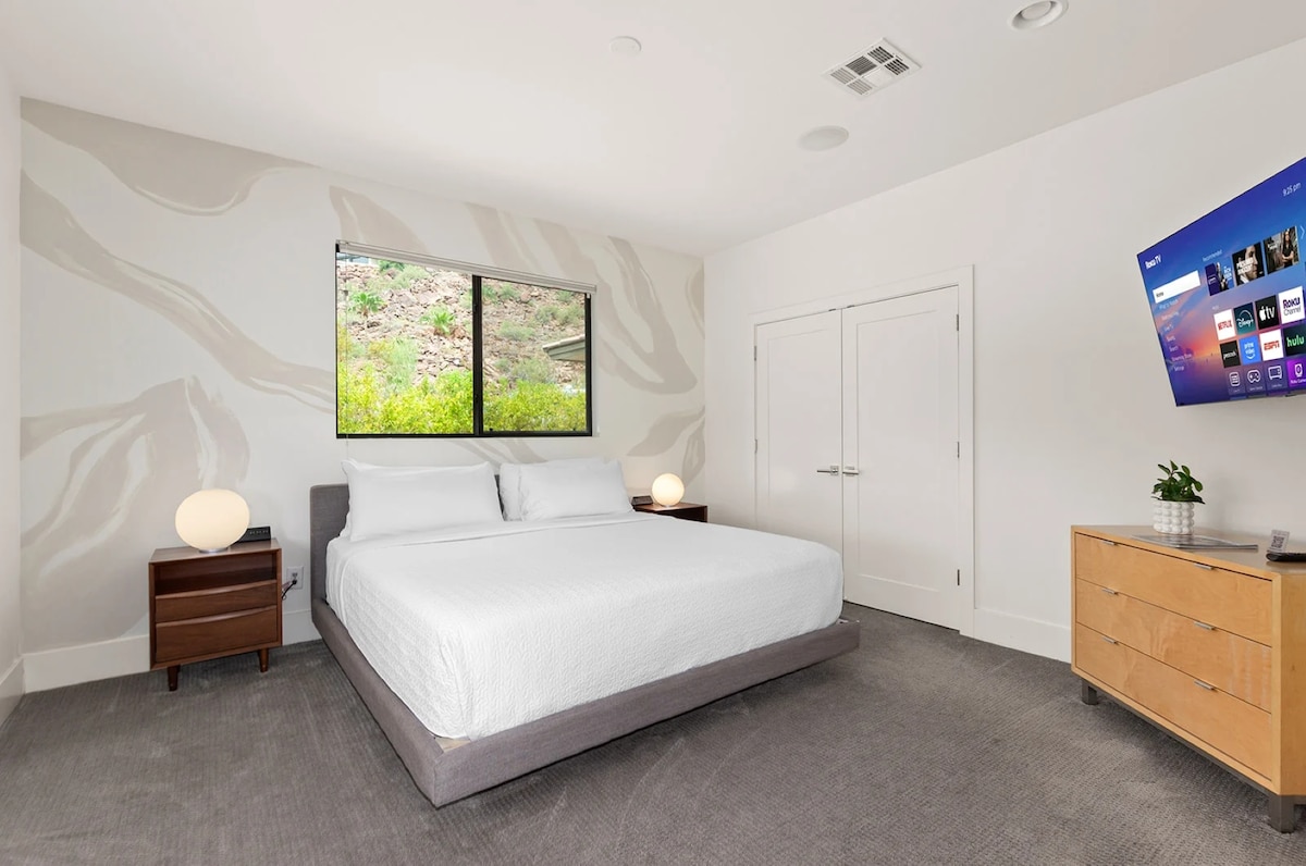 The King guest bedroom boasts stunning views of Camelback Mountain, the pool and downtown Phoenix beyond, offering a picturesque backdrop for relaxation.