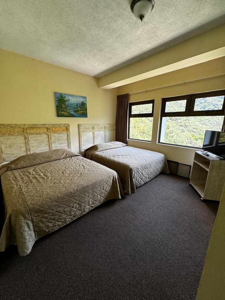 卧室配备2张标准双人床，窗外可俯瞰停车场和山景。 配备衣柜和智能电视