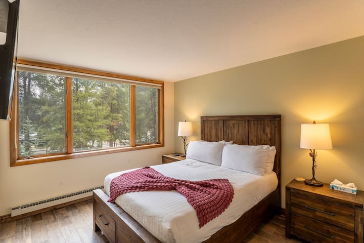 Dormitorio de invitados con una cama tamaño queen y TV inteligente.