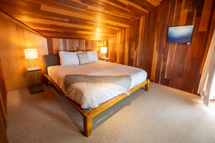 One of two bedrooms on the upstairs level. This is the smaller of the two, outfitted with a California King bed just like the other bedrooms, electrical blinds and a blackout curtain. Partial water view.
