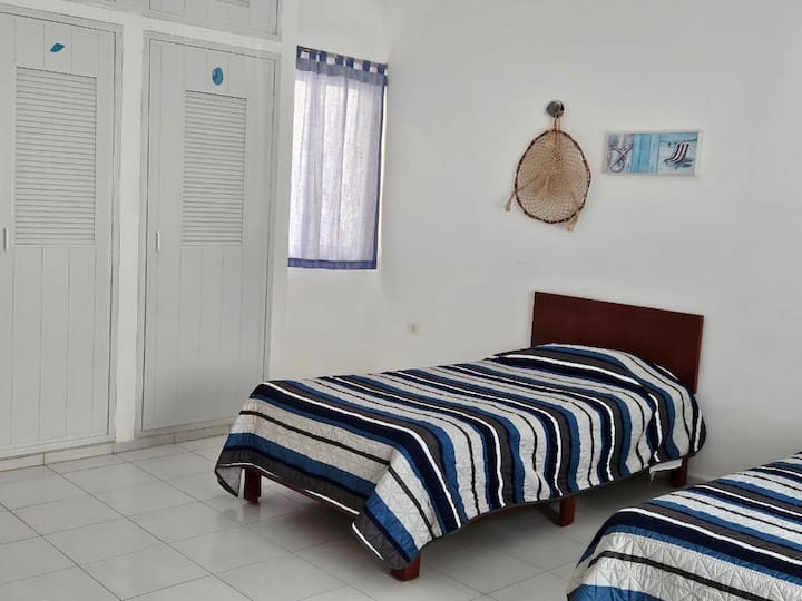 Dve jednolôžka, priestranná skriňa na uloženie oblečenia. Toaletný stolík so zrkadlom. Stropný ventilátor. Táto spálňa sa nachádza na prvom poschodí. Jedno okno je orientované na parkovisko a ulicu, druhé okno smerom k vonkajšej chodbe.   