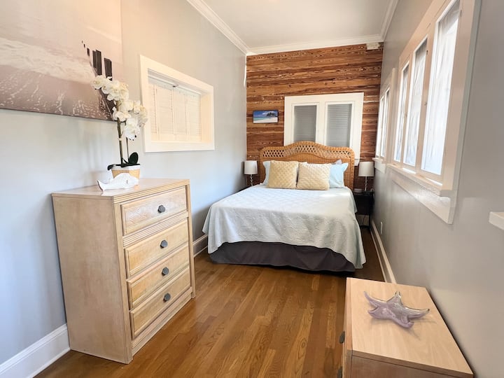 Bedroom with Queen bed and dressers for plenty of storage room. Additional closet for hanging clothes is located in main room with iron and ironing board.