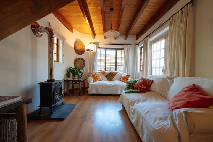 ห้องนั่งเล่น Hoepoe Cottage ได้รับการตกแต่งใหม่และปรับแต่งใหม่ให้มีเตาเผาฟืนที่ปิดสนิทเพื่อความอบอุ่นในฤดูหนาว