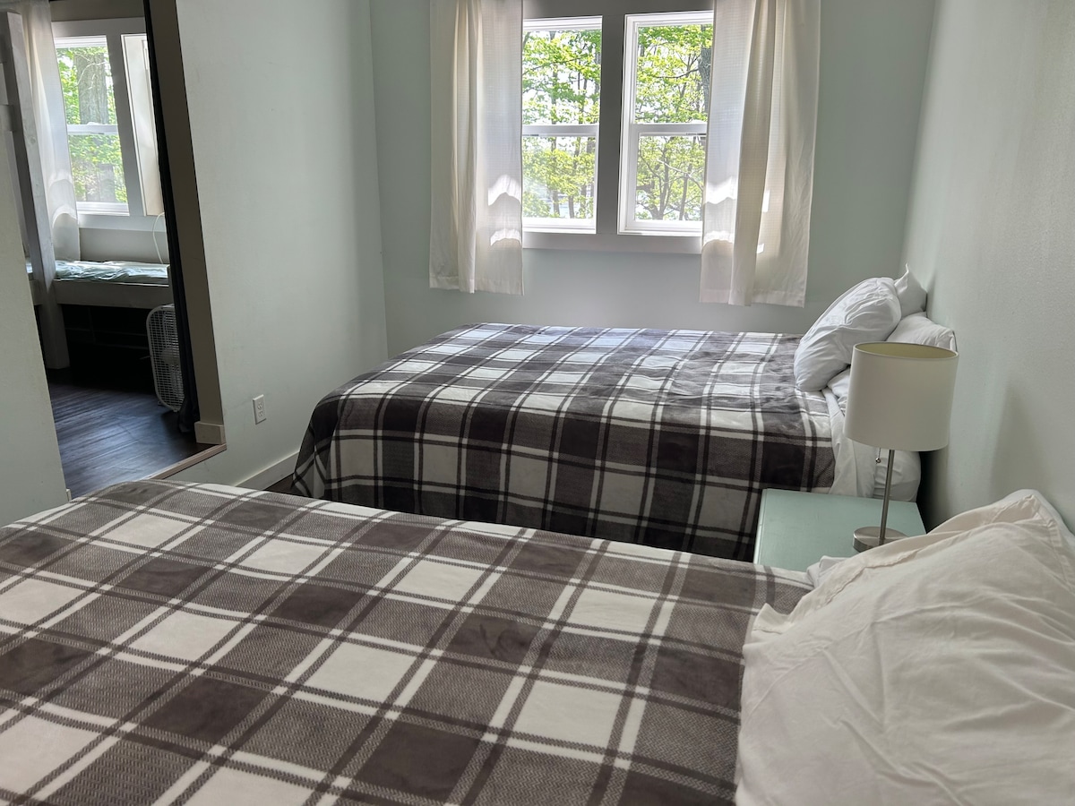 Slaaploft/stapelbedkamer boven.  Eerste ruimte heeft 2 queensize bedden.  Aangrenzende ruimte heeft 2 stapelbedden met in totaal 4 eenpersoonsbedden.