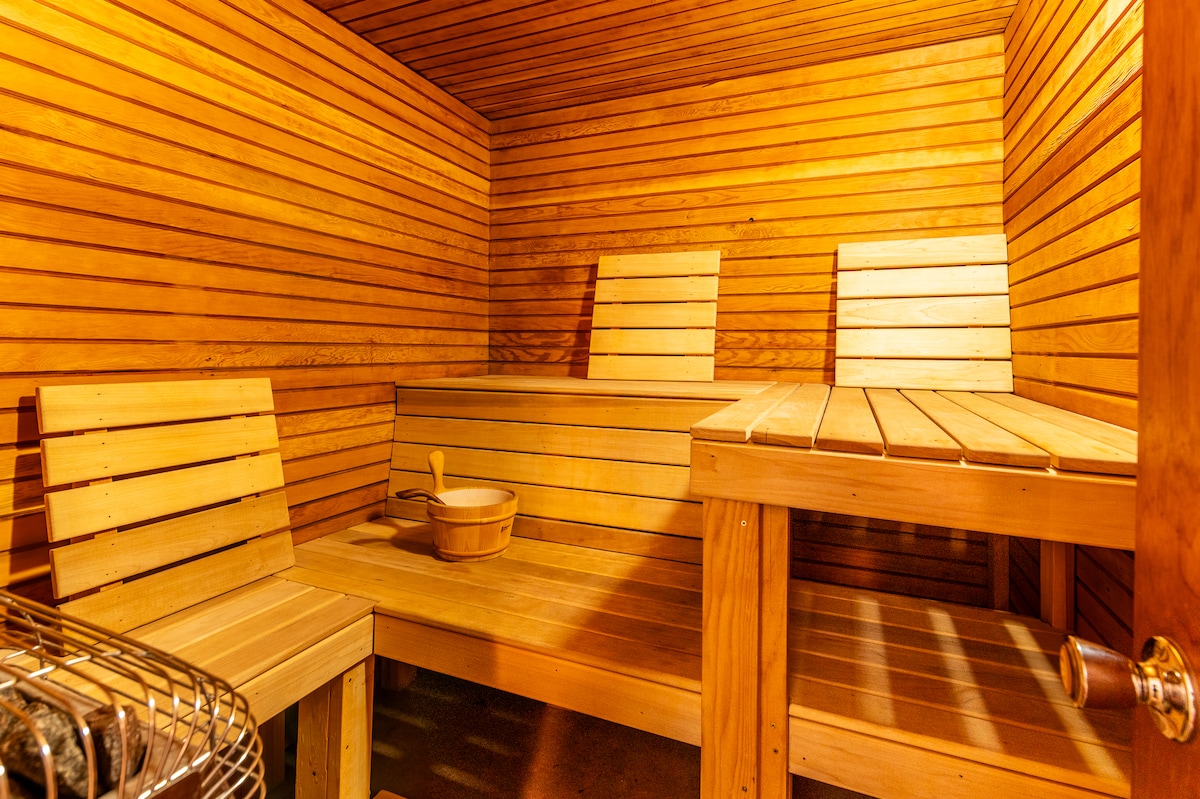 A private indoor wet sauna is showcased with warm wooden benches and walls, creating a serene environment. Equipped with a traditional sauna stove, the space offers relaxation and rejuvenation for guests looking to unwind.