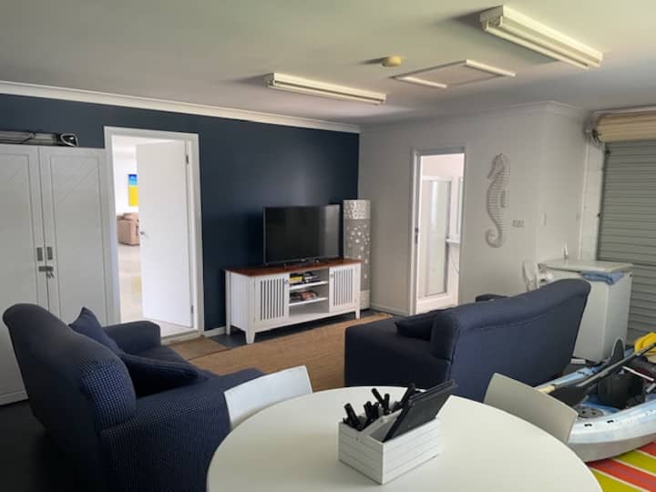 Rumpus/带餐桌的车库、2个舒适的休息室（ 1张沙发床）、带马桶和淋浴的套房、大电视和冰柜。 打开滚轮门，直接进入后院和海滨！   这间客房非常适合儿童和家庭入住。  