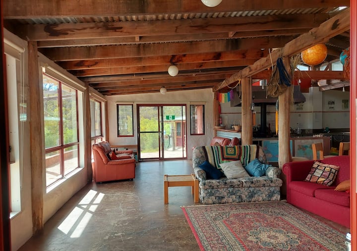 Large L shaped space with kitchen over in one corner and a wood burning stove/heater plus gas cooking in kitchen also