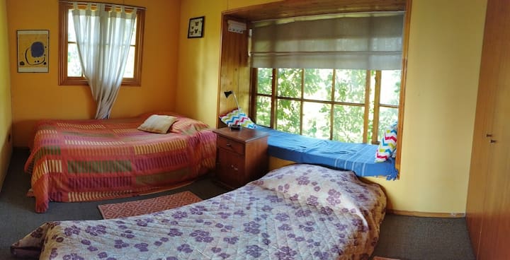 dormitorio en segundo piso con dos camas de plaza y media más medio baño en suite, vista al oriente y al sur