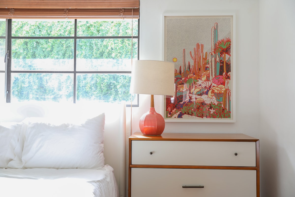 Färgglada ökenlandskapstryck från Colorado-baserade konstnär, Caroline Clark, presenteras ovanför varje nattduksbord i sovrum 2.
