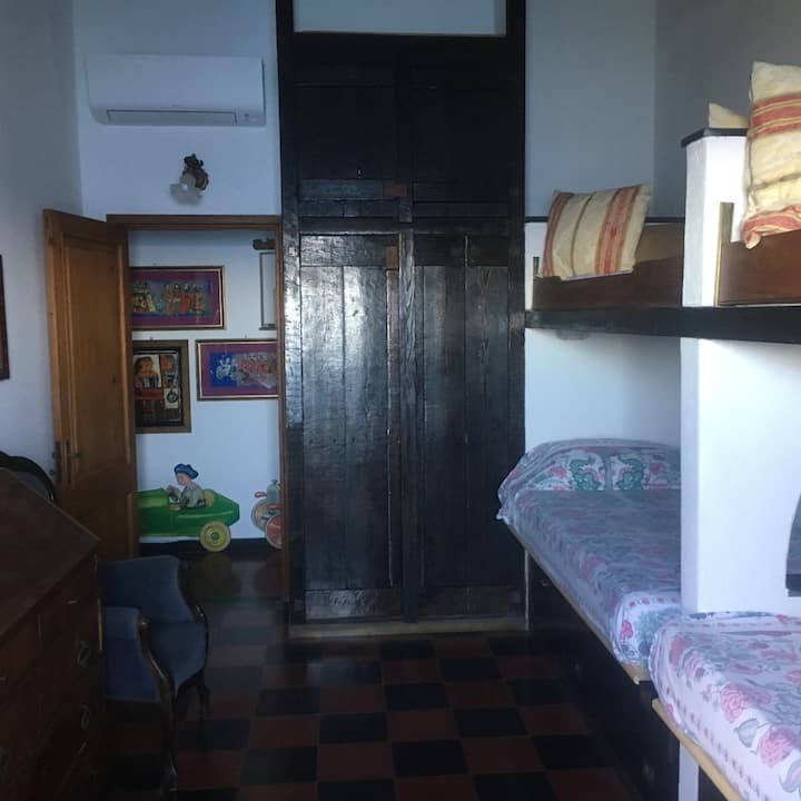Two single beds, wardrobe, dresser, air conditioning, and a small terrace.