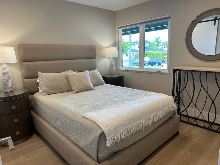 El dormitorio de invitados con cama tamaño queen tiene una gran ventana y un gran armario con cajones incorporados.