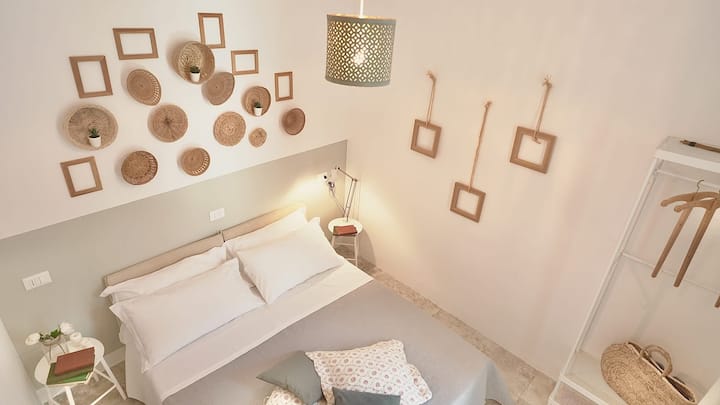 Chumba cha kulala kilicho na kitanda cha watu wawili na roshani inayoangalia ua.