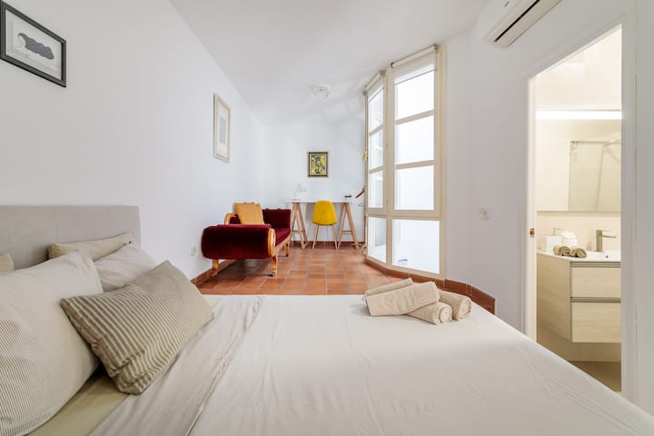 Dormitorio con baño y área de trabajo/estudio