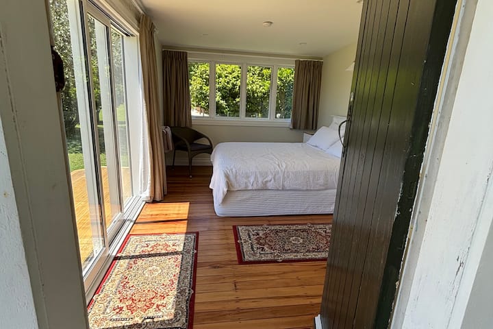 חדר שינה מרווח שנפתח אל המרפסת וחזית הים.  חלונות עם זיגוג כפול ודלתות הזזה.