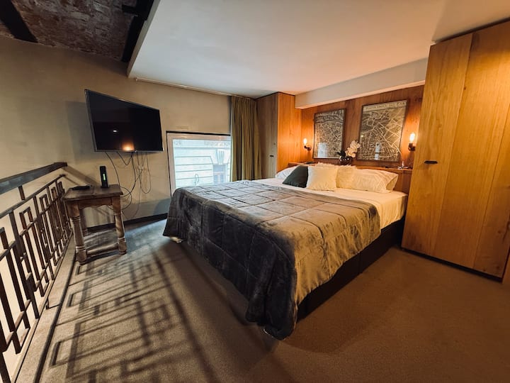 Útulná spálňa na najvyššom poschodí s inteligentným televízorom na odpočinok po prechádzke po meste.