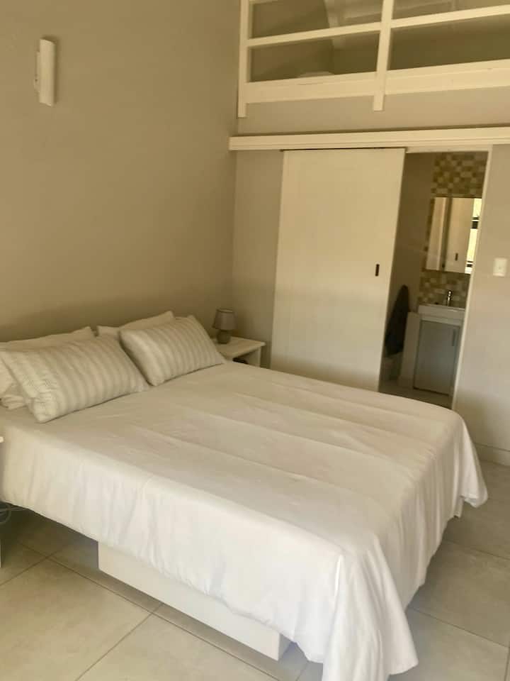 חדר שינה 3 (מקלחת צמודה), מיטה זוגית עם מזרן על הרצפה בחלל הלופט. החדר נפתח למסדרון המשותף.