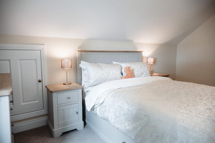 Bedroom one with King size bed and luxurious 100% cotton sheets sheets. Window looks West over the fields with the young alpaca boys in.