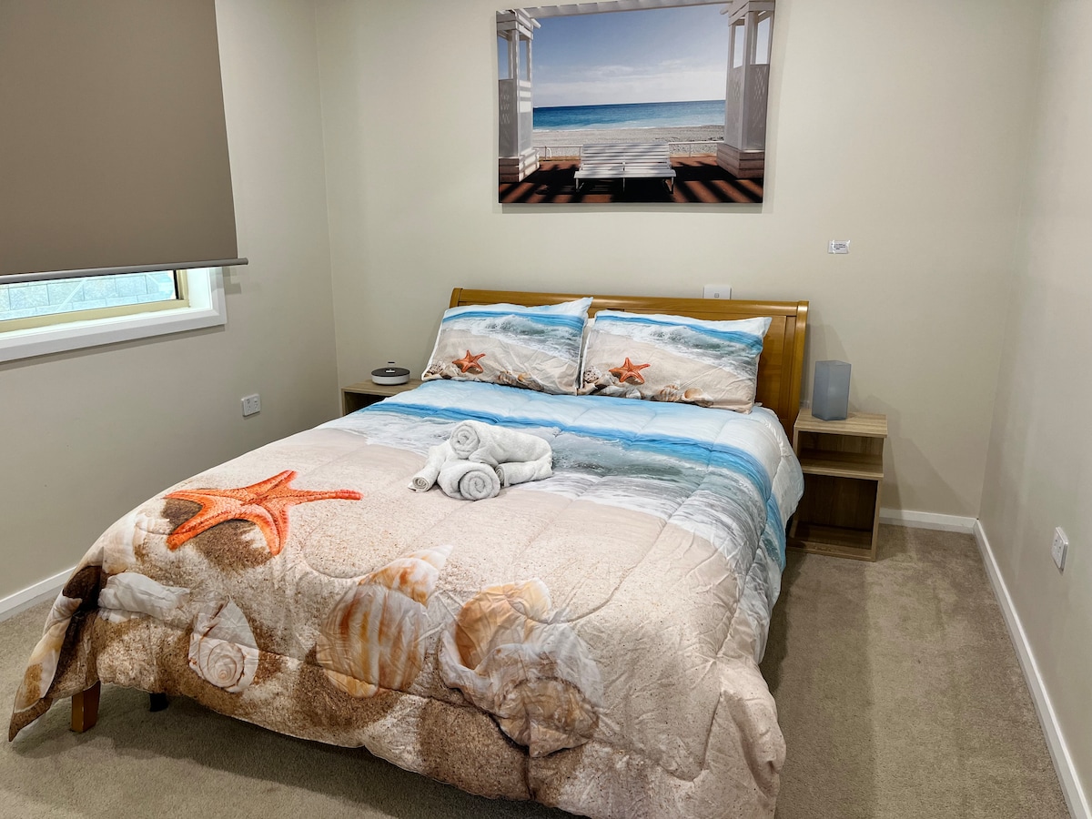 This bedroom features a queen size bed and built in wardrobe that has ample storage room for all your things. It's situated at the end of the house by the backyard and you will enjoy the quiet and sound of the ocean as you fall asleep.