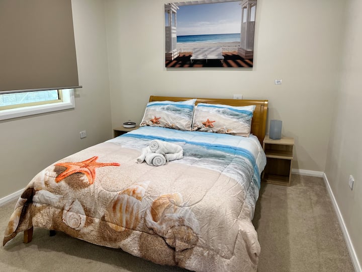 This bedroom features a queen size bed and built in wardrobe that has ample storage room for all your things. It's situated at the end of the house by the backyard and you will enjoy the quiet and sound of the ocean as you fall asleep.