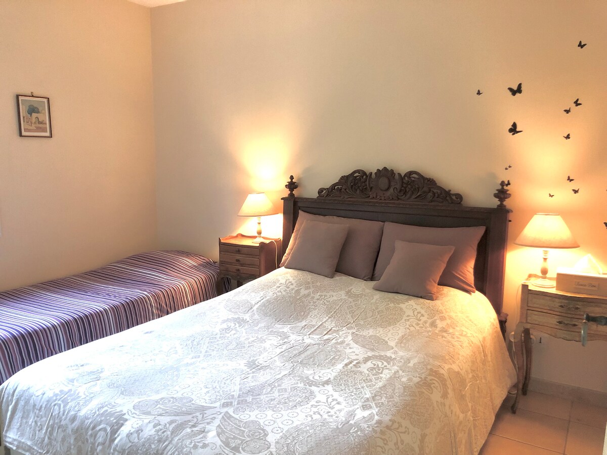 مكيف هواء وديكور أنيق بالإضافة إلى خزانة ملابس في غرفة النوم الثلاثية في الطابق العلوي من المنزل.