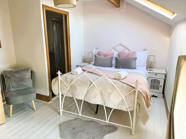 Amplio dormitorio doble en el tercer piso, con ducha en suite e inodoro. Suelos de madera, luminosos y espaciosos con ventana de velux y una gran ventana con vistas a la plaza.