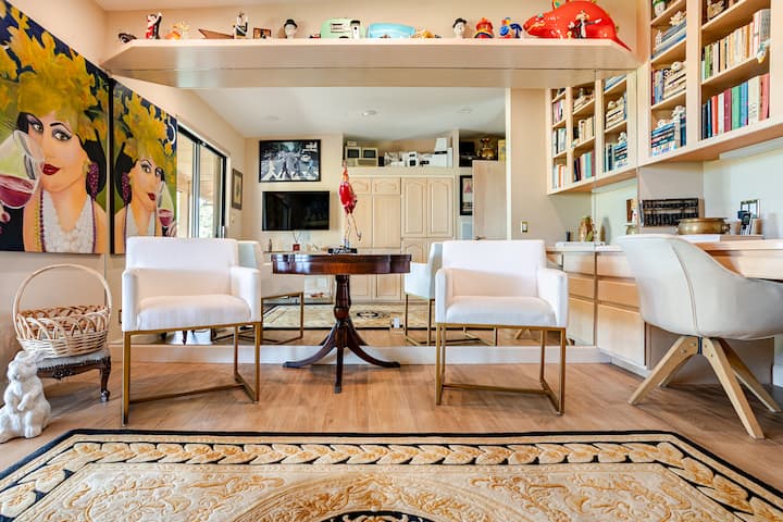 Game room/library with mirrored wall, great for working out. This room provides a  large screen TV, game table, desk and printer replete with memorabilia.