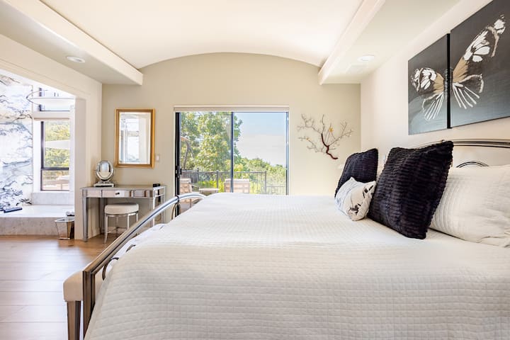 Основная спальня с кроватью размера King size и собственной ванной комнатой с джакузи, тропическим душем, двойной раковиной и туалетным столиком. Из этой спальни открывается вид на долину Сонома и большую стеклянную дверь на верхнюю террасу.