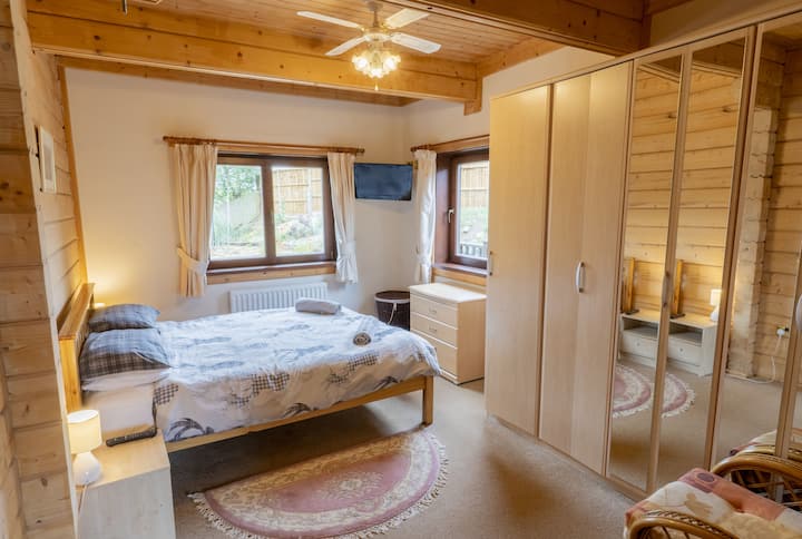 Main floor bedroom offers step-free access and a king-sized bed. There is a door to the main bathroom.