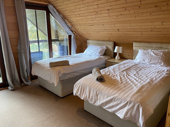 Upstairs bedroom overlooks the back garden and has two single beds and a wooden cot (not a travel cot). Balcony with view over fields. 