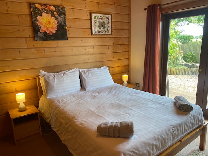 Main floor bedroom offers step-free access and a king-sized bed. Patio doors lead to the deck and back garden.