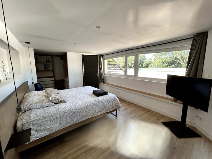 Chumba cha 26m2 kilicho na bustani nzuri, mtaro na mandhari ya bwawa. Ina dawati, kitanda mara mbili 160x200, chumba cha kuvaa na bafu lenye choo. 
Ina televisheni (Smart TV) + Sakafu yenye joto ya kuburudisha.