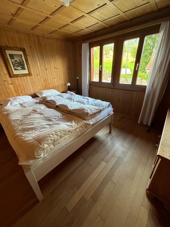 חדר שינה בקומה 1 עם מיטה זוגית ושידת מגירות.