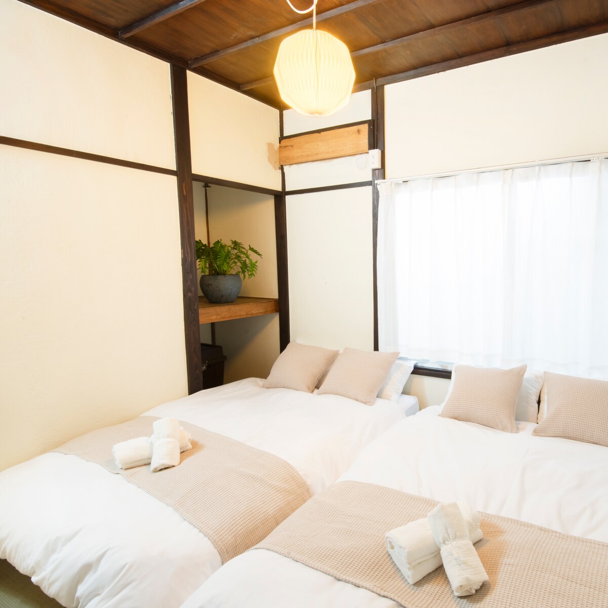 มีเตียงกึ่งคู่ 2 เตียงแสงสีอุ่นส่องผ่านหน้าต่างบานใหญ่มีเสื่อทาทามิและห้องพักให้ความรู้สึกแบบญี่ปุ่น