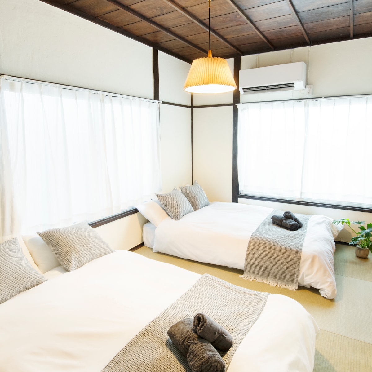 มีเตียงกึ่งคู่ 2 เตียงแสงสีอุ่นส่องผ่านหน้าต่างบานใหญ่มีเสื่อทาทามิและห้องพักให้ความรู้สึกแบบญี่ปุ่น