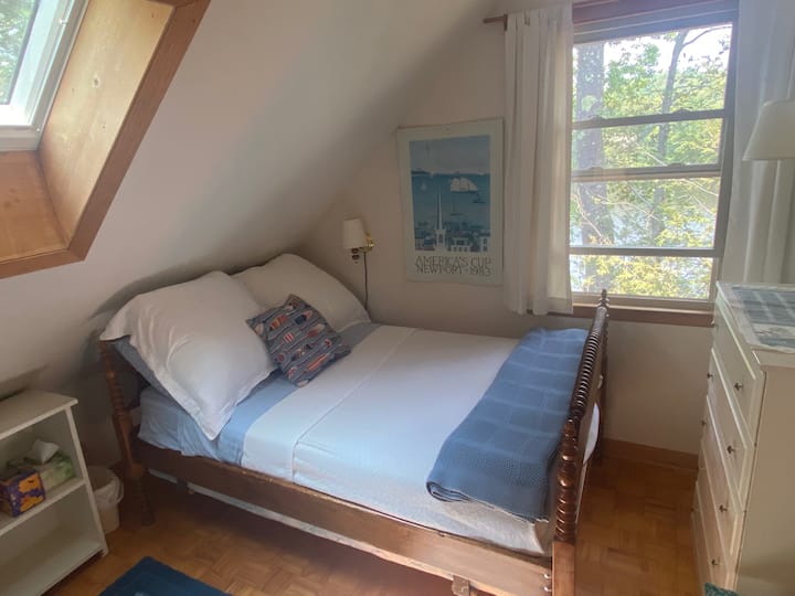 Kleines Schlafzimmer mit Blick auf den See und einem großen Bett