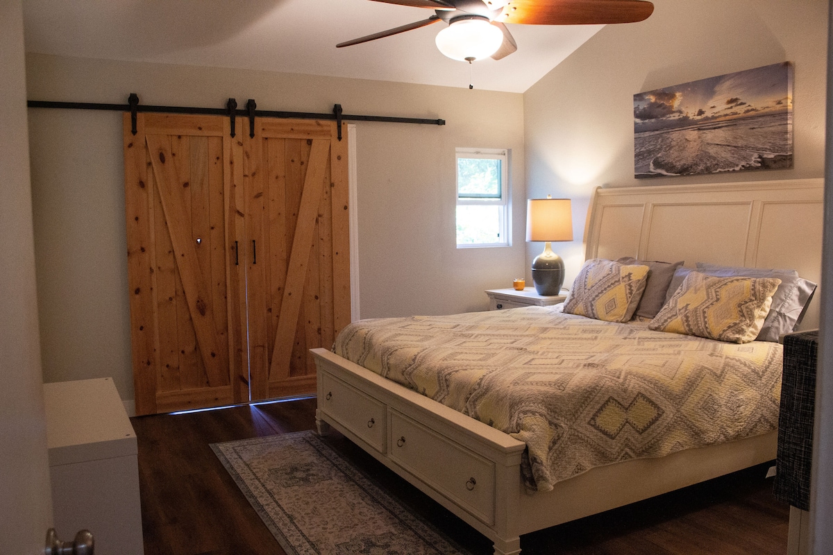 Uvoľnite sa v pokojnom hlavnom apartmáne s manželskou posteľou a klenutými stropmi.  Mäkké osvetlenie a pobrežné umelecké diela vytvárajú pokojný priestor na oddych a načerpanie nových síl.
