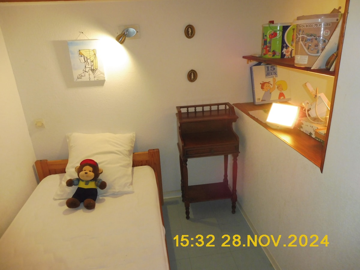 Habitación" cabaña" n°1 El apilamiento de libros infantiles y juegos en los estantes  sirve como separación