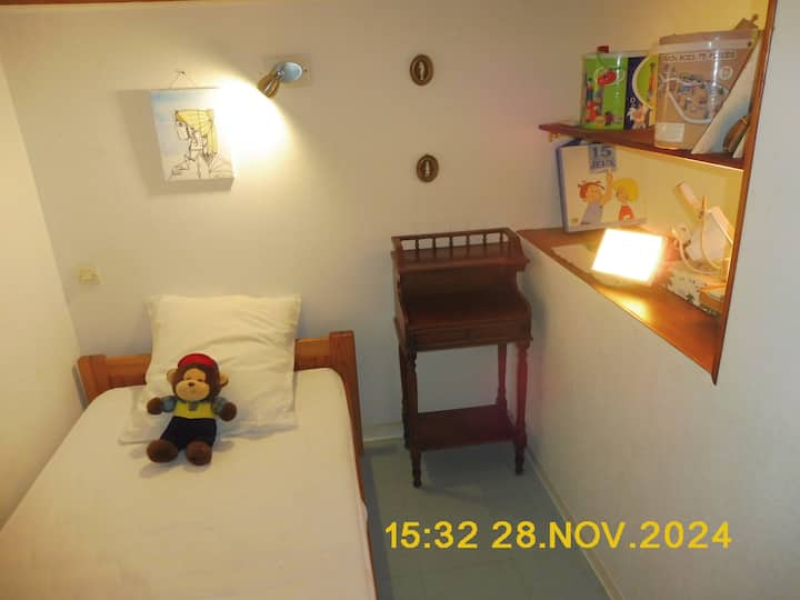 ห้องนอน "ห้องโดยสาร" #1 วางหนังสือและเกมสำหรับเด็กบนชั้นวางเพื่อเป็นการแบ่งห้อง