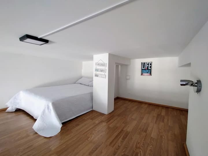 غرفة نوم علوية مع إمكانية الوصول إلى الدرج