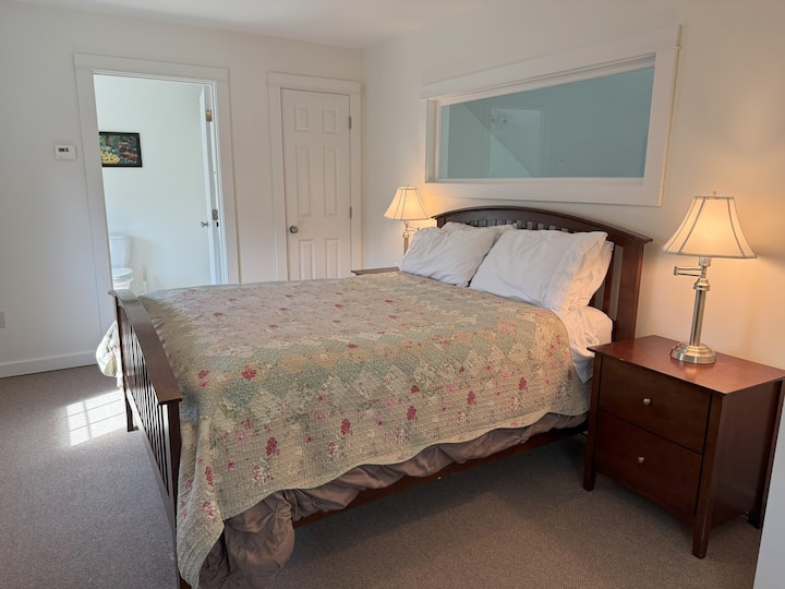 Chumba cha kulala cha ghorofa ya pili kilicho na kitanda cha kifalme na bafu lililounganishwa na bafu.