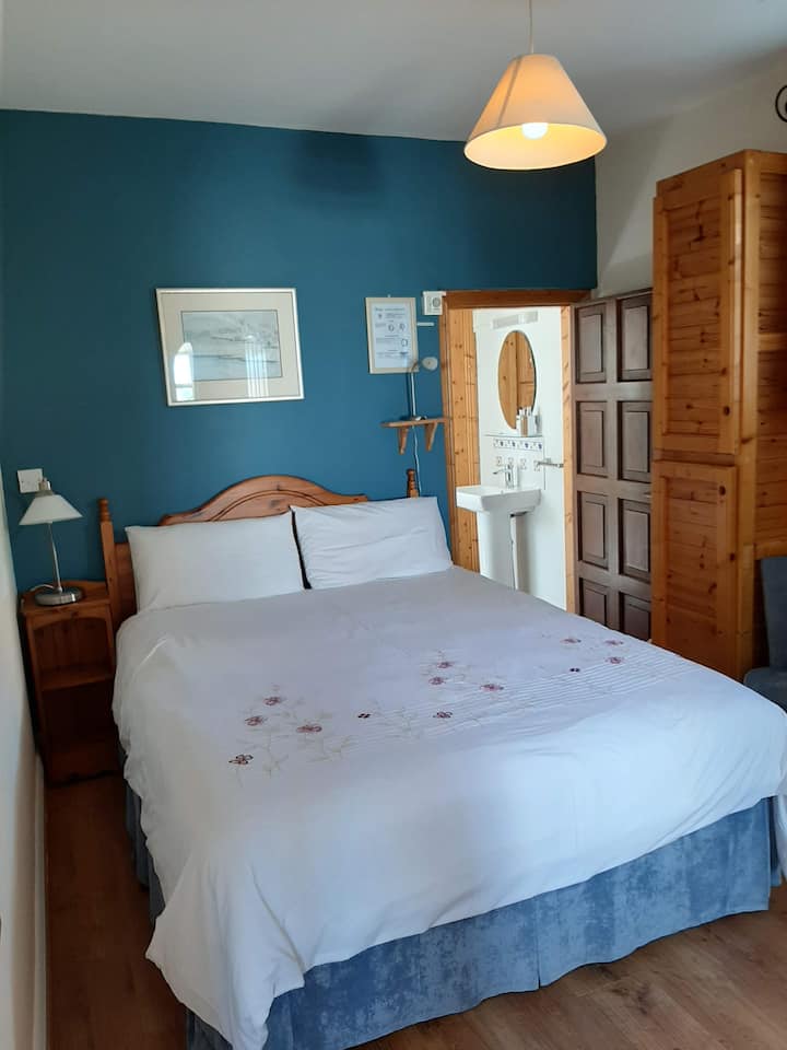 加大双人床，可以看到阳光明媚的露台，卫生间入口。